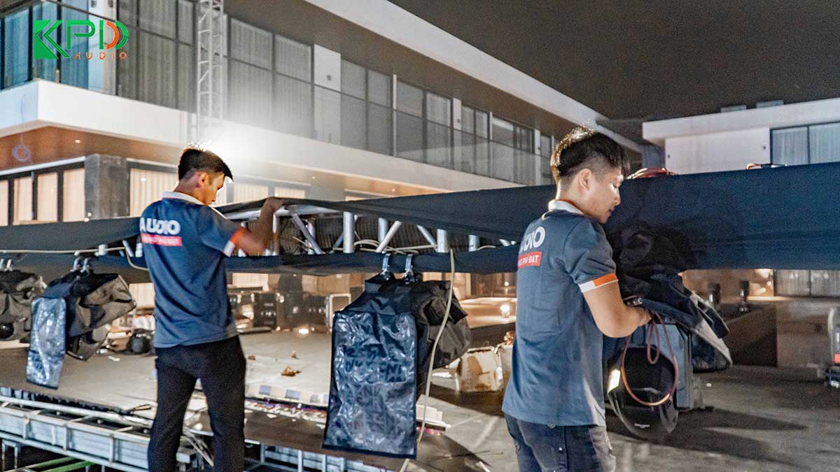 Kỹ thuật viên đang lắp đặt hệ thống đèn xoay sân khấu