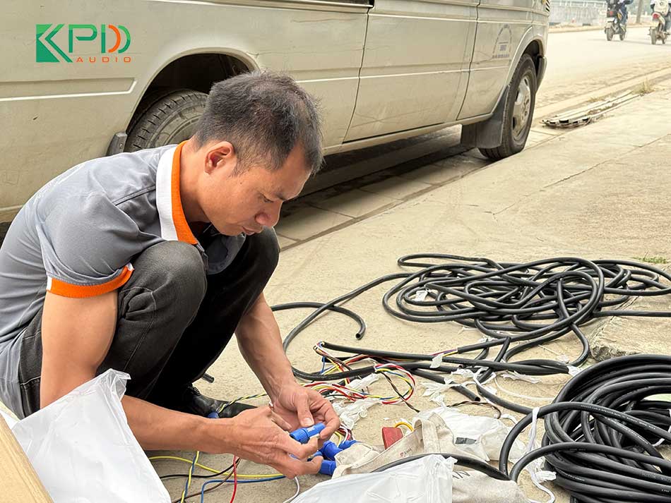 Kỹ thuật viên đang đi dây cho hệ thống âm thanh