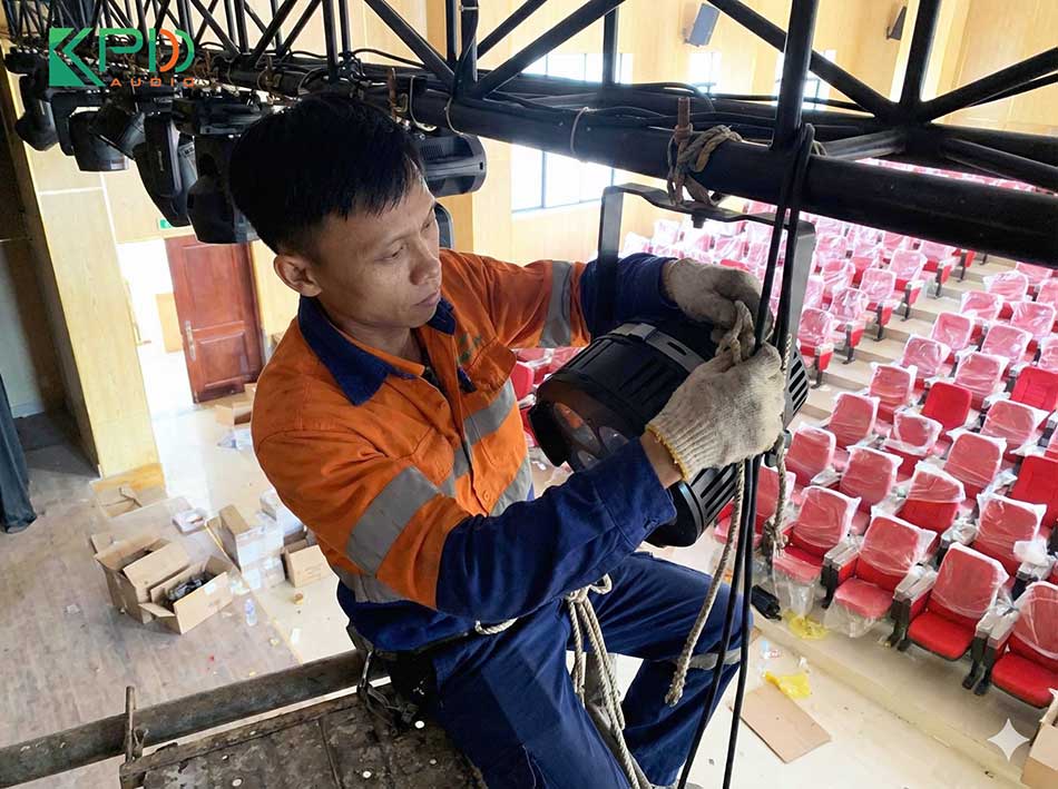 Kỹ thuật viên đang lắp đặt hệ thống đèn sân khấu HZDG
